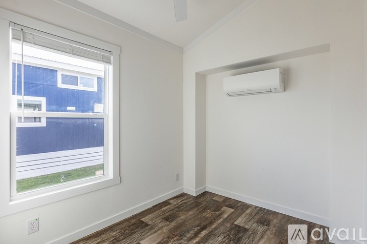 A room with a window and a wall-mounted air conditioner.