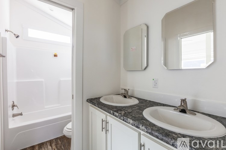 A bathroom with a tub, sink, and mirror.