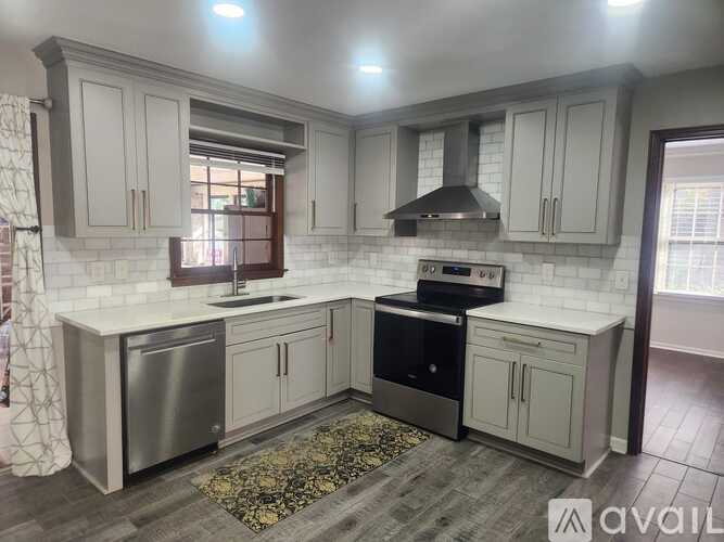 A kitchen with white cabinets and a stainless steel dishwasher.