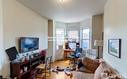A living room with a couch, chair, and television.