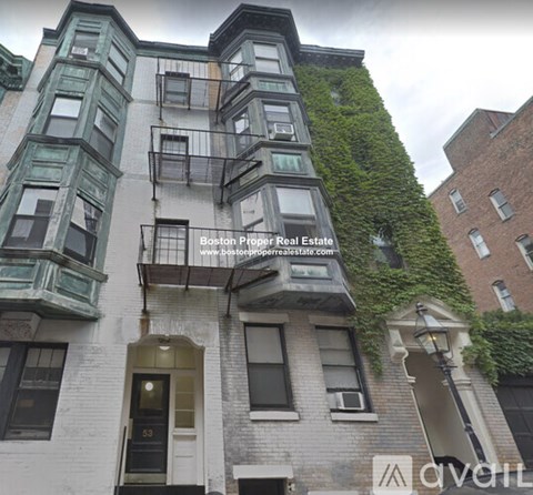 A building with a balcony covered in greenery.