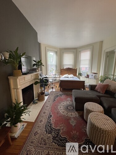 A living room with a fireplace and a rug on the floor.