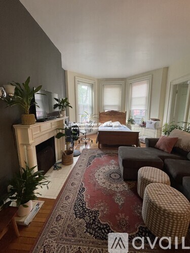 A living room with a fireplace and a rug on the floor.