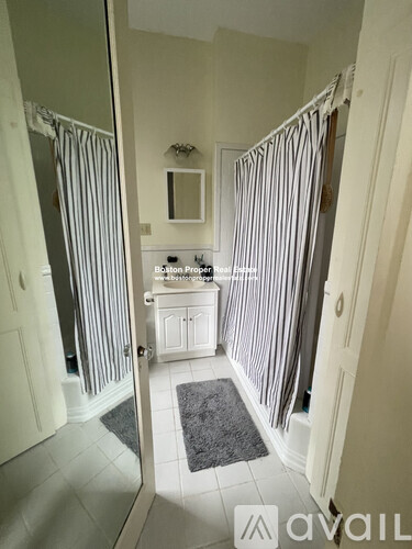 A bathroom with a white sink and striped shower curtains.