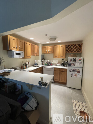 A kitchen with wooden cabinets and a white fridge.