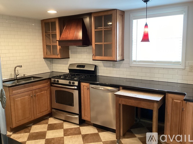 A kitchen with wooden cabinets and a black stove top oven.