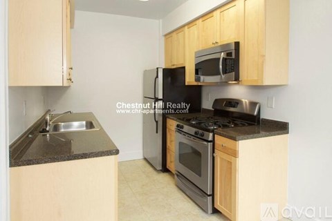 A kitchen with wooden cabinets and black appliances.