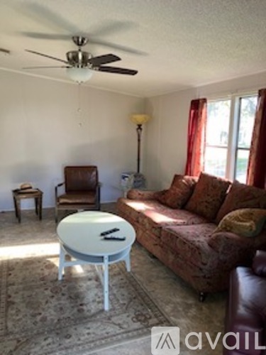 A living room with a brown couch and a white coffee table.