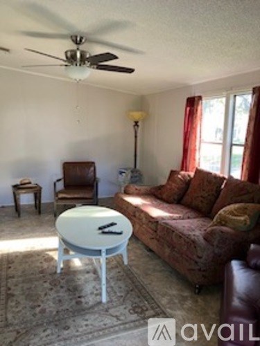 A living room with a brown couch and a white coffee table.