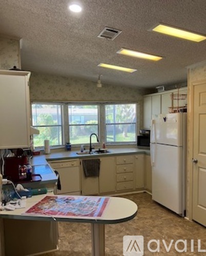 A kitchen with a table and a fridge.