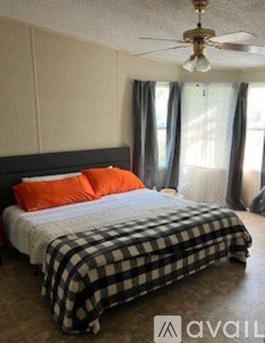 A bedroom with a bed covered in a black and white checkered comforter.