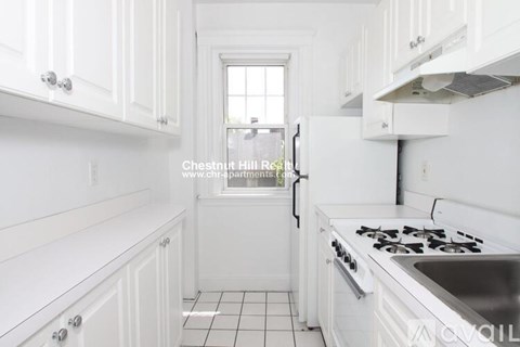 A white kitchen with a stove and sink.