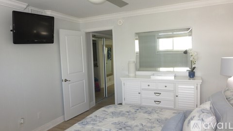A bedroom with a bed, dresser, and mirror.