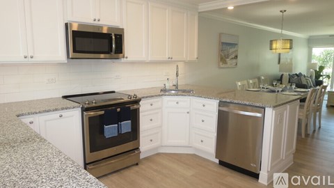 A kitchen with a granite countertop and stainless steel appliances.