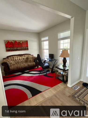 A living room with a couch, chair, and a painting on the wall.