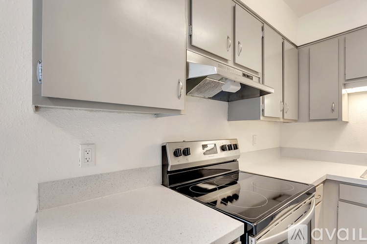 A kitchen with a stove top oven and cabinets.