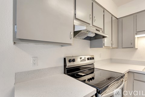 A kitchen with a stove top oven and cabinets.