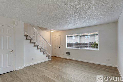 A spacious room with a staircase and a window.