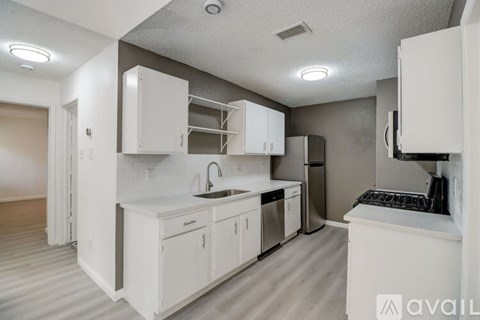 A kitchen with white cabinets and appliances is available for rent.