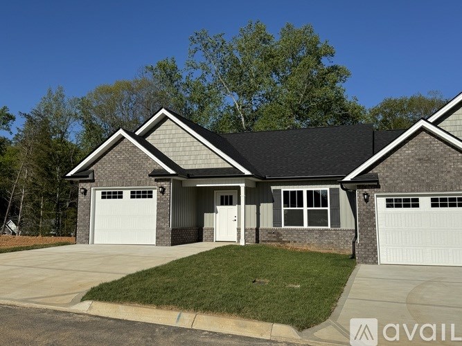A two-story house with a garage on the side.