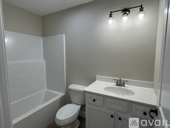A bathroom with a toilet, sink, and a shower stall.