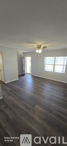 A room with wooden flooring and a ceiling fan.
