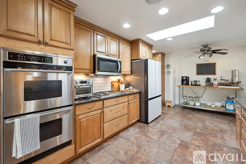 A kitchen with wooden cabinets and a stainless steel oven.