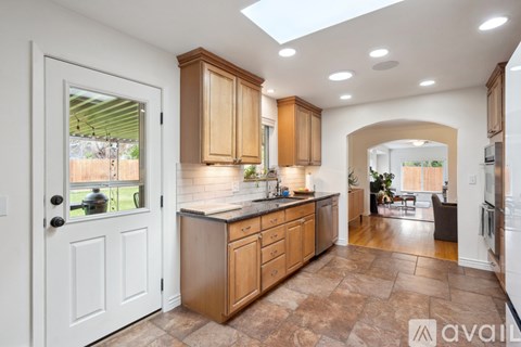 A kitchen with wooden cabinets and a skylight.
