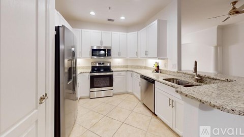 A kitchen with white cabinets and a granite countertop.