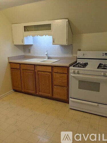 A kitchen with white appliances and wooden cabinets.