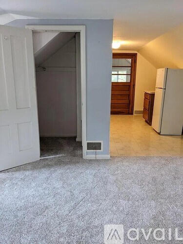 A room with a white door and a white fridge.