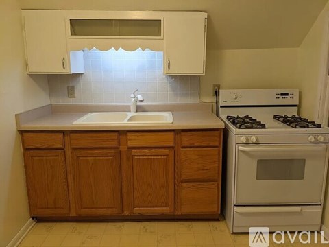 A kitchen with wooden cabinets and a white stove.