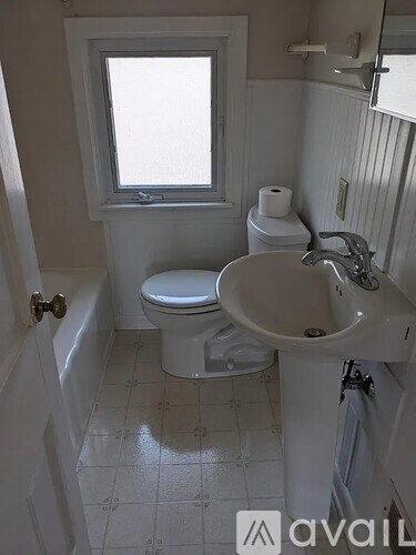 A white toilet and sink in a small bathroom.