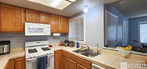 A kitchen with wooden cabinets and a white stove top oven.