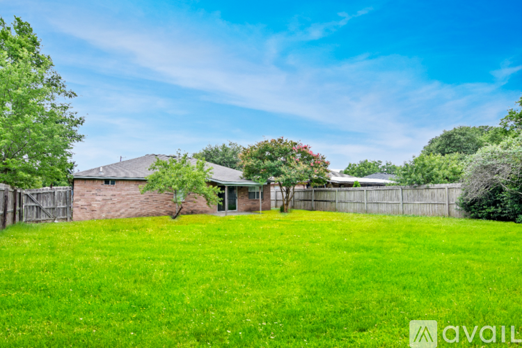 A house with a fence and green grass in front.