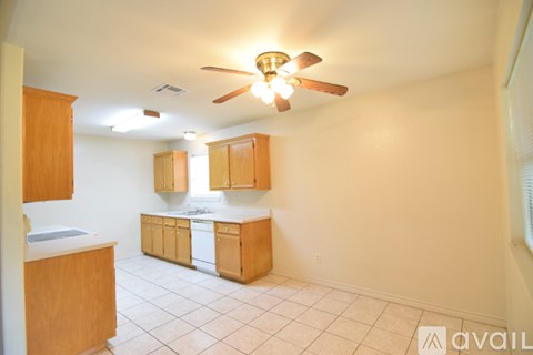 A kitchen with wooden cabinets and a ceiling fan.
