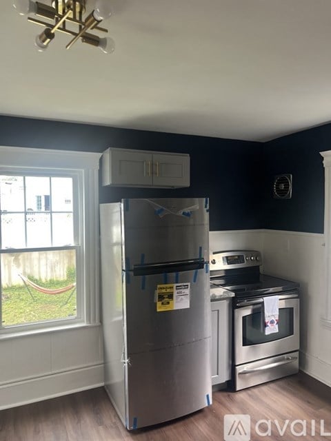 A kitchen with white cabinets and a window.
