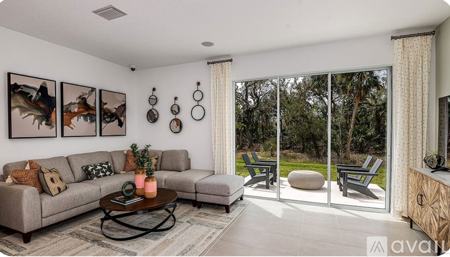 A living room with a grey couch, a coffee table, and a painting on the wall.