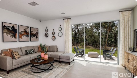 A living room with a grey couch, a coffee table, and a painting on the wall.