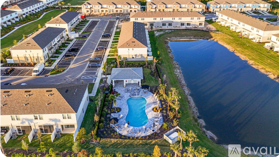 A bird's eye view of a residential area with a swimming pool and a lake.