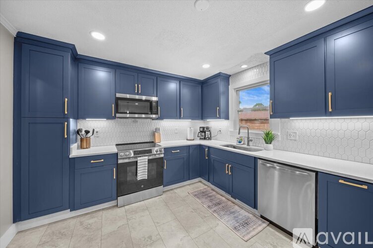 A kitchen with dark blue cabinets and stainless steel appliances.