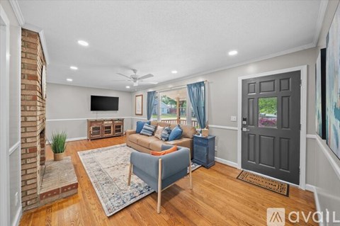 A living room with a blue sofa and a television on the wall.