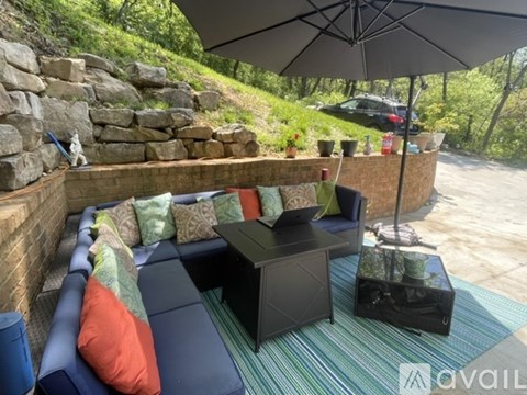 A black umbrella is over a black coffee table.