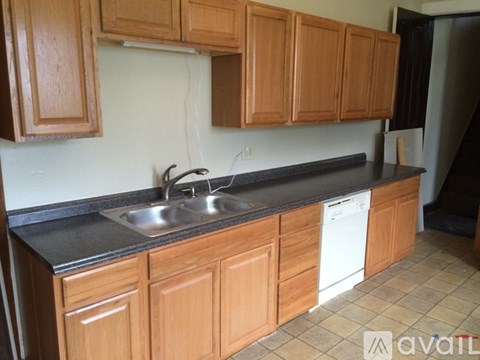 A kitchen with wooden cabinets and a black countertop.