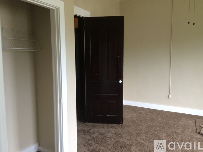A black door is in a white room.