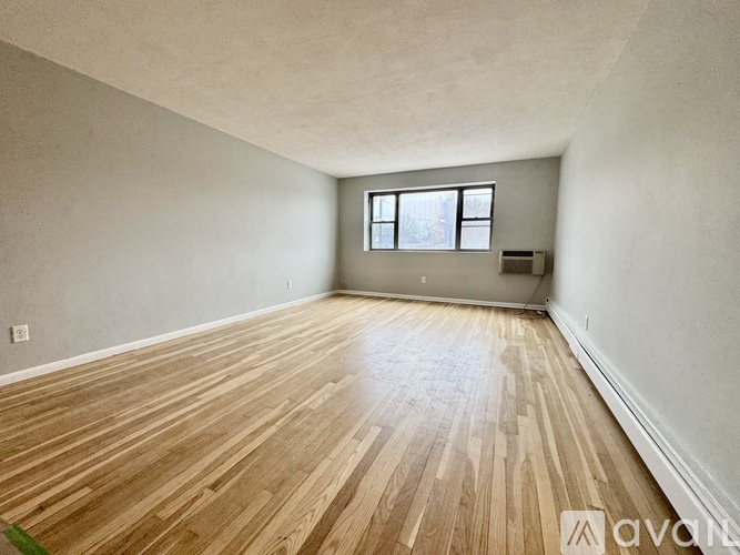 A room with wooden flooring and a window.