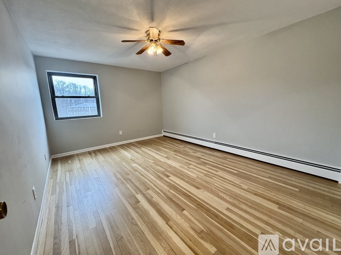 A room with wooden flooring and a ceiling fan.