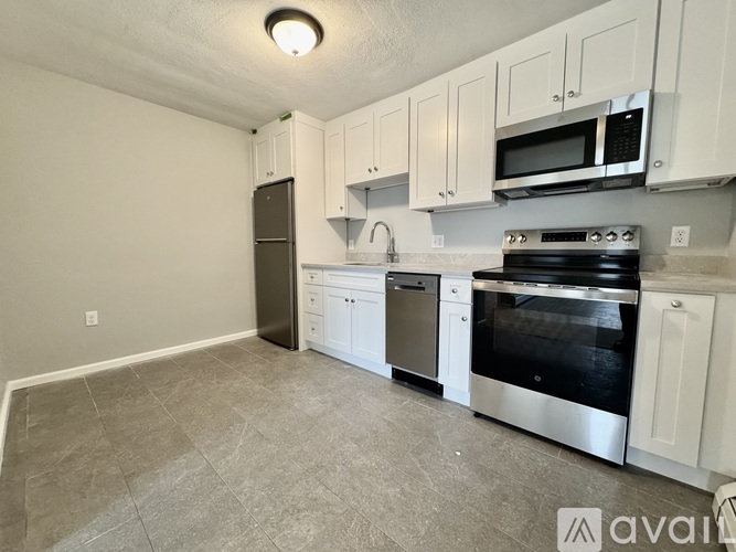 A kitchen with white cabinets and stainless steel appliances.