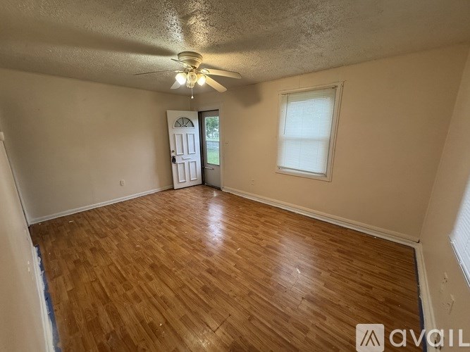 A room with wooden flooring and a ceiling fan.