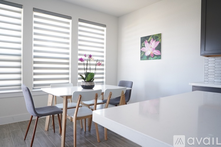 A dining room with a white table and chairs.